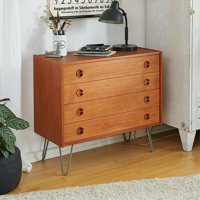 Wagner System Möbelfuß Hairpinlegs - Stahl, Höhe: 20 cm, Grau - Eine Mid-Century-Kommode aus Holz mit vier Schubladen und eleganten Metallbeinen, dekoriert mit einer Lampe, Stiften und Papieren.