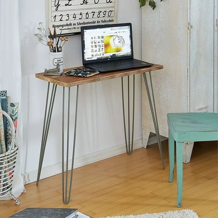 Wagner System Möbelfuß Hairpinlegs - Stahl, Höhe: 71 cm, Grau - Ein schmaler Holztisch mit Haarnadelbeinen steht in einem Raum. Ein Laptop, Stifte und andere Gegenstände stehen auf der Tischplatte.