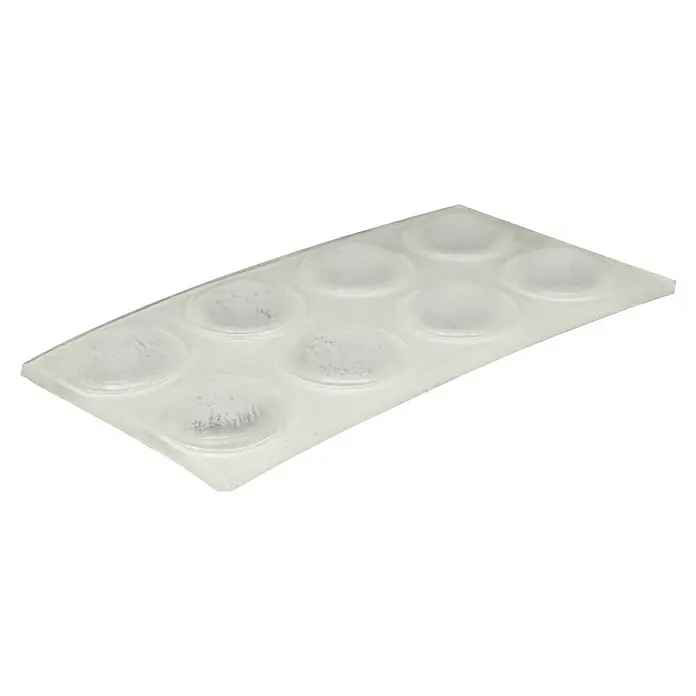 Wagner System Möbelgleiter - Durchmesser: 10 mm, Rund - Dieses Bild zeigt eine Nahaufnahme einer Packung mit transparenten, selbstklebenden Dämpfern, die auf einer Folie angeordnet sind.