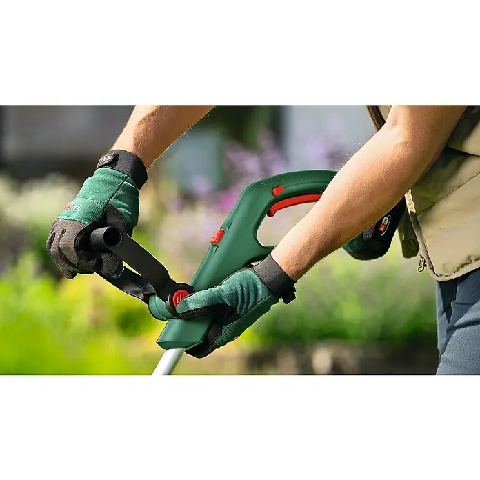 Bosch Power for All 18V Akku-Rasentrimmer UniversalGrassCut 18V-26-50018 V, Li-Ionen, Ohne Akku - Der Akku-Rasentrimmer von Bosch wird mit Handschuhen bedient, um präzise Rasenkanten zu schneiden.