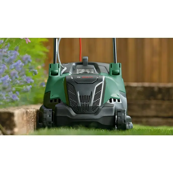 Bosch Elektro-Rasenmäher AdvancedRotak 44-750 - 1.800 W, Schnittbreite: 44 cm - Ein grüner Bosch Rasenmäher auf Rasen vor einem Holzzaun, mit Blumen im Hintergrund. Der Rasenmäher ist gut sichtbar.