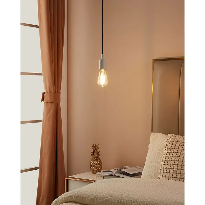 Eglo connect.z Smart-LED-Lampe ST64 - E27, Dimmbar, Warmweiß, 806 lm, 6 W - Dieses Bild zeigt eine Hängelampe mit Glühbirne über einem Nachttisch mit Dekorationen in einem Schlafzimmer.