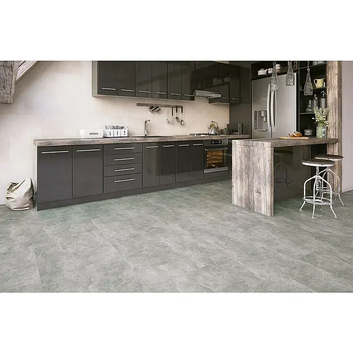 Classen Laminat Visiogrande - Bright concrete, 604 x 280 x 8 mm - Moderne Küche mit grauen Schränken, einer Kücheninsel mit Barhockern und einem grauen Fliesenboden. Die Küche wirkt stilvoll und einladend.