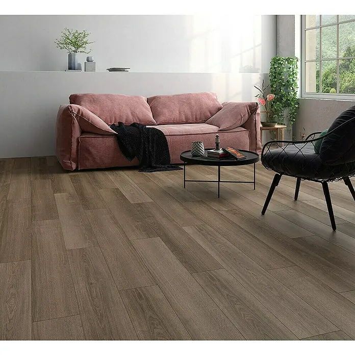 Classen Laminatmuster 731-4 - 300 x 194 x 7 mm, Landhausdiele, Nelson - Helles Wohnzimmer mit Parkettboden, rosa Sofa, rundem Tisch und Sessel. Der Holzboden verleiht dem Raum eine warme Atmosphäre.