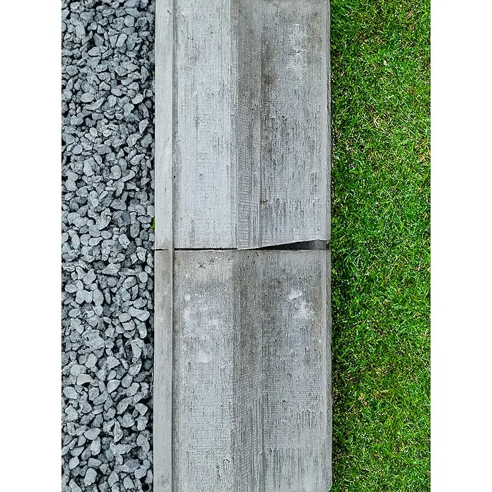 Diephaus L-Stein - 24 cm, 40 cm, Grau - Nahaufnahme von zwei grauen Betonrandsteinen, die ein Beet mit Kies von einem Rasen trennen. Ein rustikaler Gartenakzent.