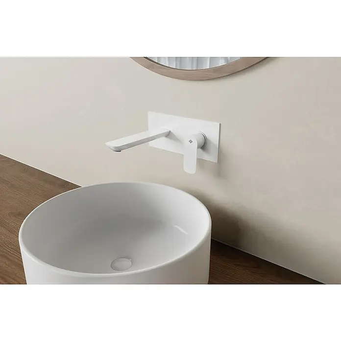 IO Cassio Grifo de lavabo Cassio - Blanco - Primer plano de un moderno grifo de pared blanco y un lavabo redondo que enfatizan un diseño de baño minimalista.
