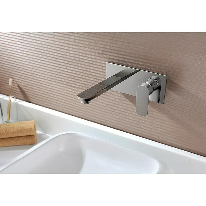 IO Cassio Grifo de lavabo Cassio - Cromo - Primer plano de un moderno grifo de baño de pared con un diseño elegante y un acabado cromado brillante en un baño.
