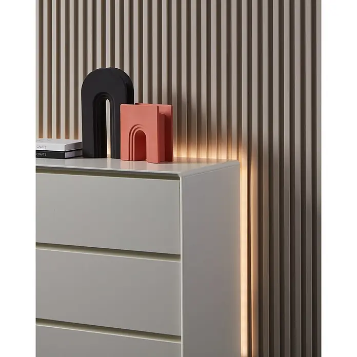 Eglo connect.z LED-Band - Länge: 500 cm, Lichtfarbe: RGBW, 1.250 lm - Dekoratives Interieur mit minimalistischen Bögen in Schwarz und Lachsfarbe auf einer weißen Kommode, vor einer gerillten Wand.