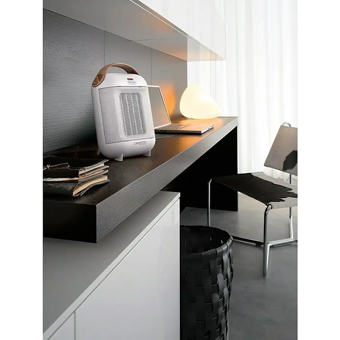 De'Longhi Calefactor de aire Capsule - 900 W - 1.800 W, Blanco - Elegante foto de un calefactor cerámico De'Longhi sobre un escritorio moderno, combinando confort y diseño contemporáneo.