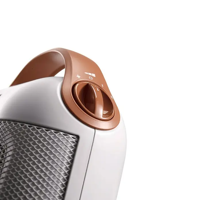 De'Longhi Calefactor de aire Capsule - 900 W - 1.800 W, Blanco - Primer plano de un calefactor, con un botón giratorio para ajustar la configuración de calor. El calefactor es blanco con detalles marrones.