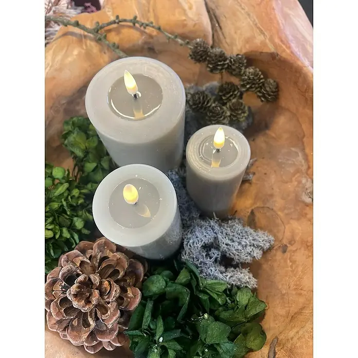 DeluxeHomeart LED-Kerze Indoor - Weiß, Ø x H: 7,5 x 15 cm, Echtwachs - Drei LED-Kerzen mit verschiedenen Größen in einem Holzgefäß mit Tannenzapfen und Grünzeug für eine stimmungsvolle Dekoration.