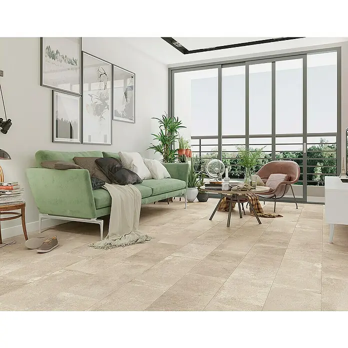 Classen Laminat Visiogrande - Sand beige, 604 x 280 x 8 mm - Ein helles Wohnzimmer mit einer grünen Couch, Bildern an der Wand und großen Fenstern, die viel Tageslicht hereinlassen.