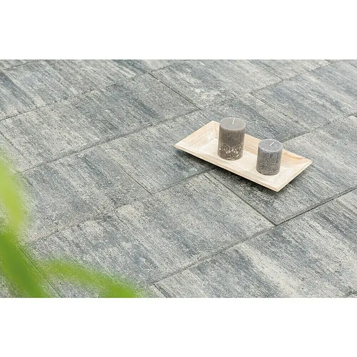 Diephaus Terrassenplatte Vallejo - 60 x 30 x 4 cm, Weiß/Schwarz, Beton - Das Bild zeigt graue Pflastersteine mit zwei Kerzen auf einem hellen Holztablett. Das Produkt ist für den Außenbereich und verleiht dem Garten eine elegante Note.
