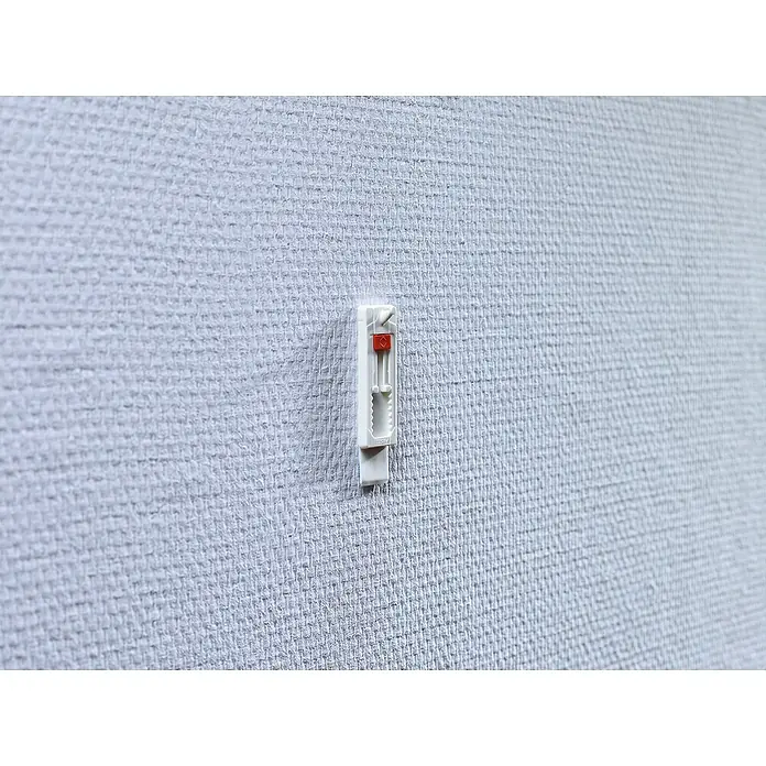 Tesa Verstellbarer Klebenagel - Geeignet für: Tapeten, Belastbarkeit: 1 kg, Weiß, 4 Stk. - Nahaufnahme einer weißen, verstellbaren Bilderhaken an einer strukturierten Wand. Das rote Element dient zur einfachen Justierung der Höhe.