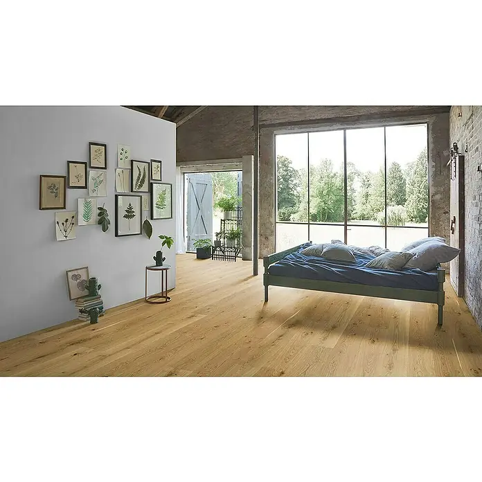 Parador Parkettmuster Basic Eiche Naturöl - 200 x 185 x 11,5 mm, Landhausdiele - Ein helles Schlafzimmer mit einem Holzboden, einem Bett mit blauer Bettwäsche und botanischen Illustrationen an der Wand sorgt für eine ruhige Atmosphäre.