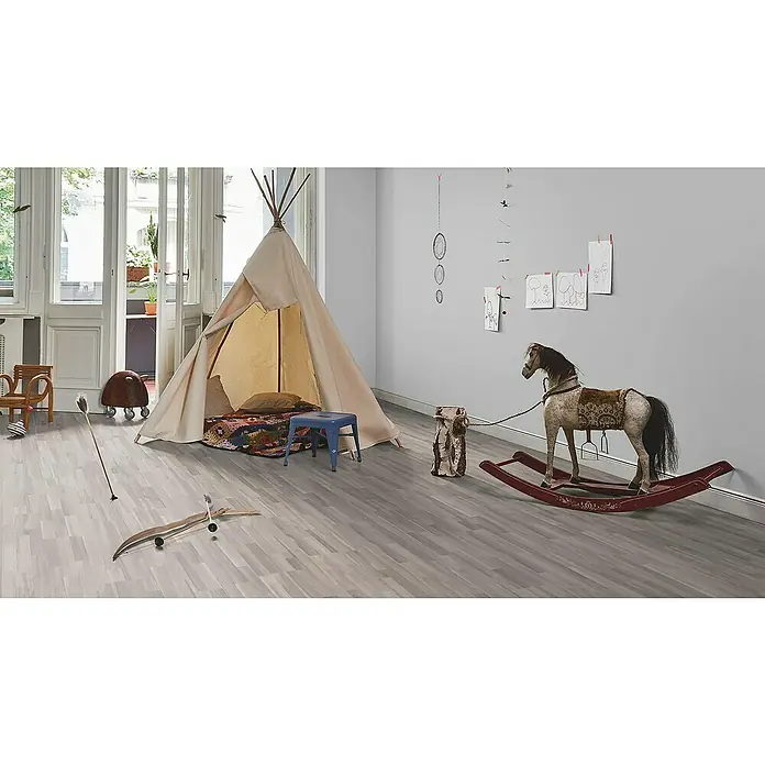 Parador Laminatmuster Basic 200 Akazie grau - 200 x 194 x 7 mm, Schiffsboden - Ein helles Kinderspielzimmer mit einem Spielzelt, einem Schaukelpferd und farbenfrohen Dekorationen an der Wand.