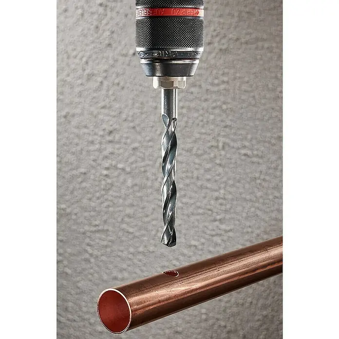 Wolfcraft Metallbohrer rollgewalzt - Durchmesser Bohrer: 10 mm - Bohrer über Kupferrohr mit kleinem Loch, bereit zum Bohren. Das Werkzeug ist scharf und bereit für die Arbeit.