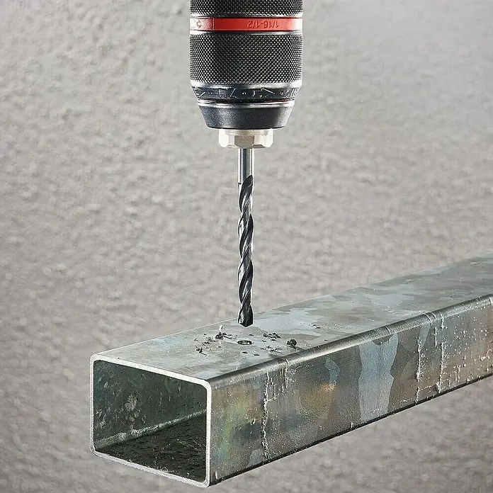 Wolfcraft Metallbohrer rollgewalzt - Durchmesser Bohrer: 10 mm - Nahaufnahme einer Bohrmaschine beim Bohren eines Lochs in ein Vierkantrohr aus Metall. Das Werkzeug ist präzise und effizient im Einsatz.