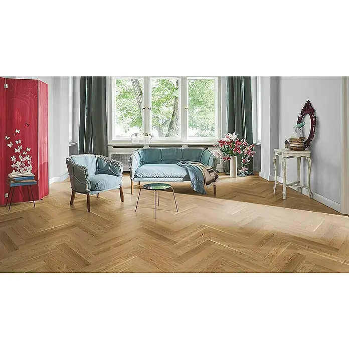 Parador Parkett Trendtime - Eiche, Fischgrät, 570 x 95 x 10,5 mm - Das Bild zeigt einen hellen Raum mit Fischgrätparkett. Der Raum ist mit hellblauen Möbeln und Vorhängen in Grau dekoriert.
