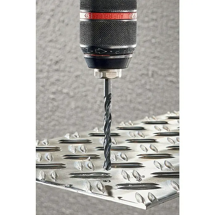 Wolfcraft Metallbohrer rollgewalzt - Durchmesser Bohrer: 10 mm - Ein Bohrer bohrt ein Loch in eine strukturierte Metallplatte. Das Werkzeug ist präzise und effektiv für diese Aufgabe.