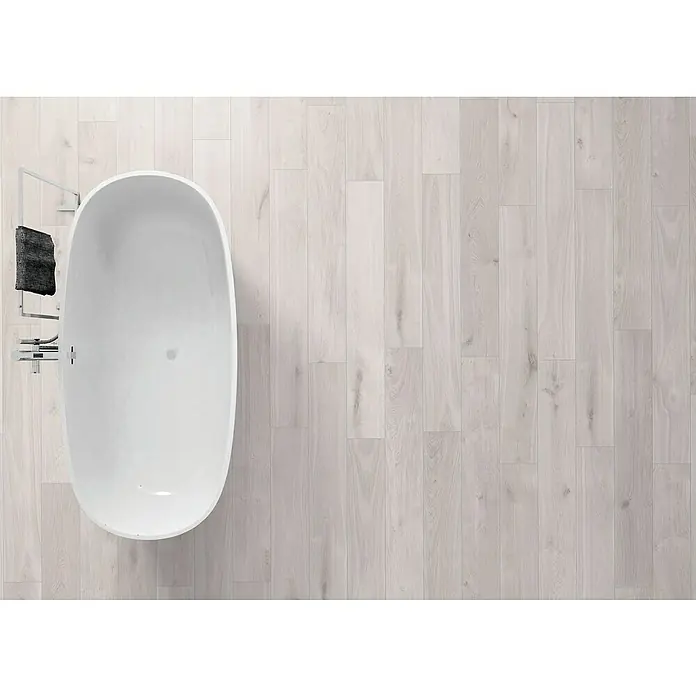 Krono Original Vinylbodenmuster Rocko Classic Airflow - 297 x 192 x 5 mm, Landhausdiele, Airflow - Draufsicht auf eine moderne Badewanne auf einem hellen Holzboden, daneben ein Handtuchhalter. Elegantes Badezimmerdesign mit klaren Linien.
