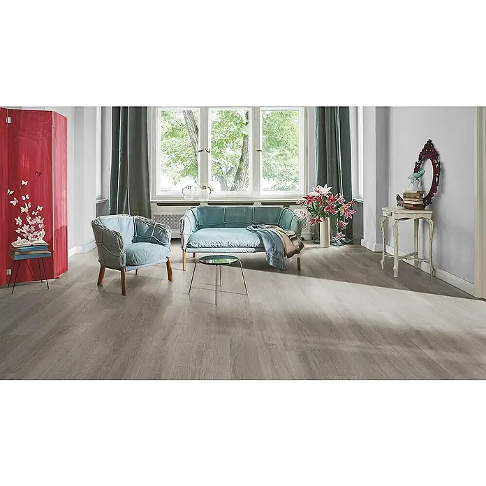 Parador Laminatmuster Basic 200 Eiche lichtgrau - 200 x 194 x 7 mm, Landhausdiele - Ein helles Wohnzimmer mit grauem Bodenbelag, einem blauen Sofa und Sesseln, sowie einem roten Raumteiler. Der Bodenbelag sorgt für eine moderne Atmosphäre.
