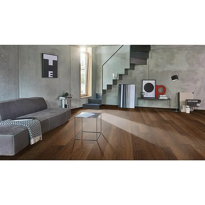 Parador Laminatmuster Basic 200 Walnuss - 200 x 194 x 7 mm, Landhausdiele - Modernes Wohnzimmer mit stilvollem Holzboden, grauer Couch und minimalistischen Möbeln für ein elegantes Ambiente.