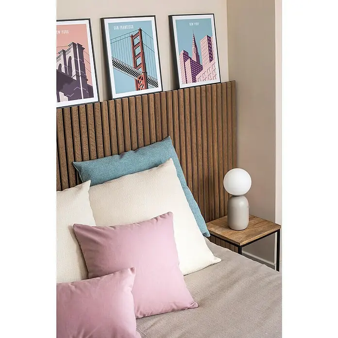 Cuadro San Francisco - An x Al: 30 x 40 cm, 1 pzs. - Primer plano de una cama con almohadas decorativas, una lámpara de noche y obras de arte con temática de ciudad en un cabecero de madera.