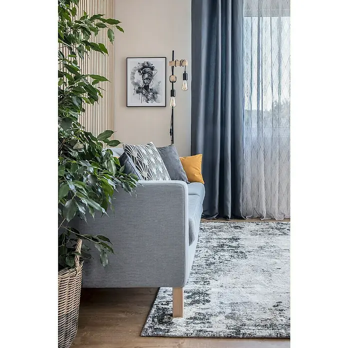 Eglo Townshend Stehleuchte - 20 W, Höhe: 166,5 cm, Braun/Schwarz, E27 - Ein modernes Wohnzimmer mit einem grauen Sofa, einem dekorativen Teppich und einer Zimmerpflanze, die eine gemütliche Atmosphäre schaffen.