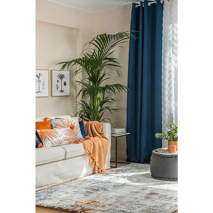 Manta para sofá Eira - 130 x 170 cm, Poliéster, Melocotón - Salón con sofá blanco, cojines decorativos, planta de interior y cortina azul para un ambiente acogedor.