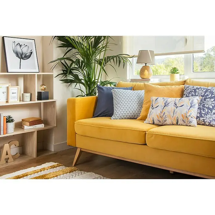 Dekit Estantería de madera Lis - Al x An x Pr: 96 x 110 x 25 cm, Número de baldas: 3 ud., Atornillado, Natural - Acogedora sala de estar con un sofá amarillo mostaza adornado con cojines estampados, junto a una estantería luminosa.