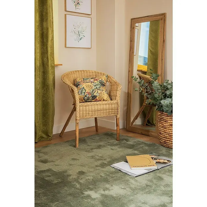 Espejo de pared DM Lisboa - 54 x 144 cm, Roble - Escena acogedora con una silla de ratán con cojín de jungla, un espejo y una alfombra verde con libro. Crea un ambiente confortable.