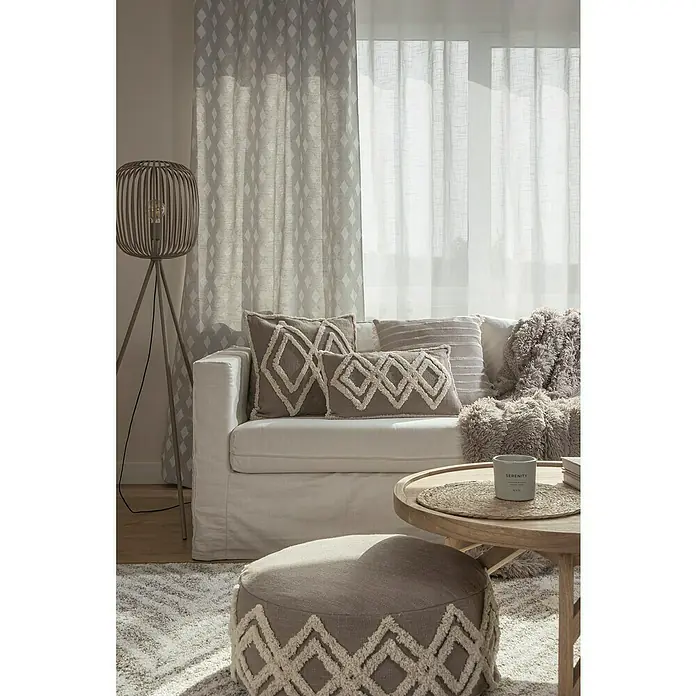 Cojín Tufted Joy - 50 x 30 cm, Textil, Taupé, Rectangular - Salón con un sofá blanco, cojines decorativos con estampado de diamantes y un puf a juego, acentuado por cortinas y una lámpara de pie decorativa.
