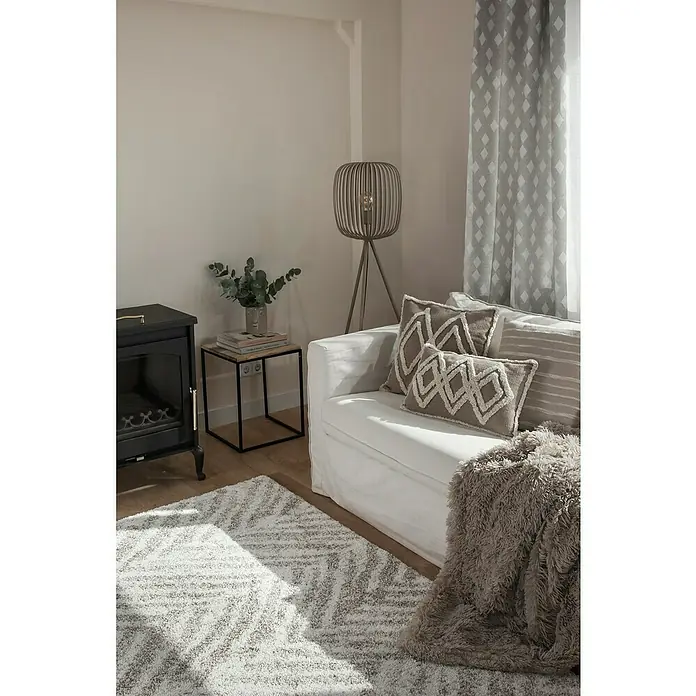 Cortina con ollaos Duko - An x Al: 140 x 260 cm, Perla - Un acogedor salón con un sofá blanco, cojines decorativos y una alfombra de felpa, creando un ambiente relajante y acogedor.