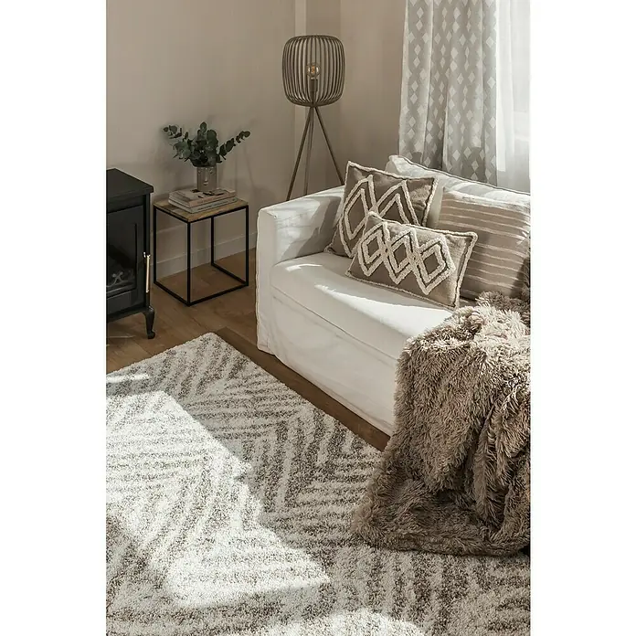 Manta para sofá Luxury - Multicolor - Primer plano de una elegante sala de estar con una alfombra estampada, un sofá blanco con cojines decorativos y una lámpara de pie con estilo.