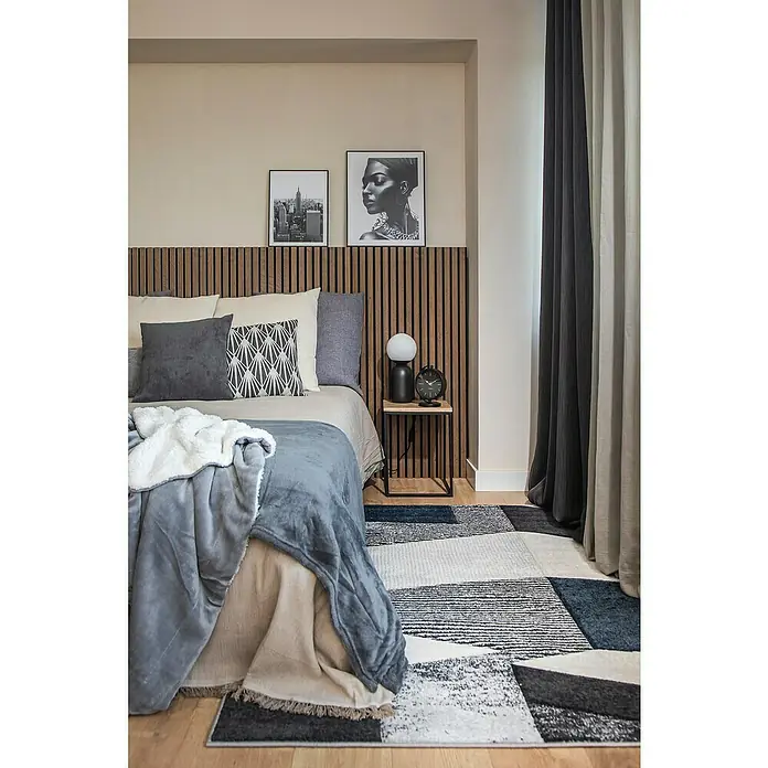 Manta para sofá Chicago - 130 x 150 cm, Gris - Dormitorio con cama, lámpara de noche, fotos y alfombra geométrica que añade un toque moderno a la habitación.
