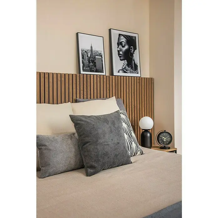 Cojín Estructura Velvet - 50 x 30 cm, Textil, Gris, Rectangular - Primer plano de una cama elegante con cojines decorativos, una lámpara de noche y un reloj moderno, complementado con una decoración de pared elegante.