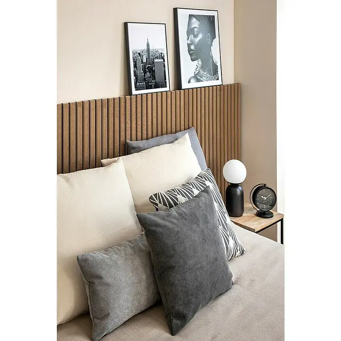 Cojín Pana - 45 x 45 cm, Poliéster, Gris, Cuadrado - Decoración de dormitorio con cojines cómodos en tonos grises y crema, complementado con una lámpara elegante y un reloj en una mesita de noche.
