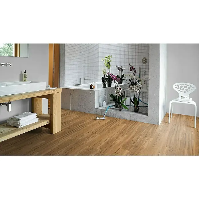 Parador Vinylbodenmuster Basic 30 Eiche Memory Natur - 200 x 216 x 9,4 mm, Landhausdiele - Ein Badezimmer mit braunem Holzboden, einer Badewanne und einem Waschtisch mit Handtüchern, der eine gemütliche und stilvolle Atmosphäre schafft.