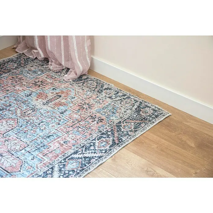 Cortina con ollaos Daniele - An x Al: 140 x 260 cm, Rosa - Vista detallada de una alfombra estampada en tonos de azul, rosa y gris, sobre un suelo de madera y acentuada por una cortina rosa.
