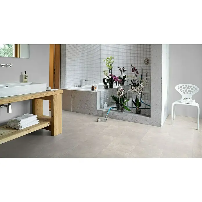 Parador Designboden Modular One - Beton Weiß, Fliese, 853 x 400 x 8 mm - Ein Badezimmer mit einem freistehenden Waschtisch aus Holz, einer Badewanne und einem weißen Design-Stuhl, das eine entspannende Atmosphäre schafft.
