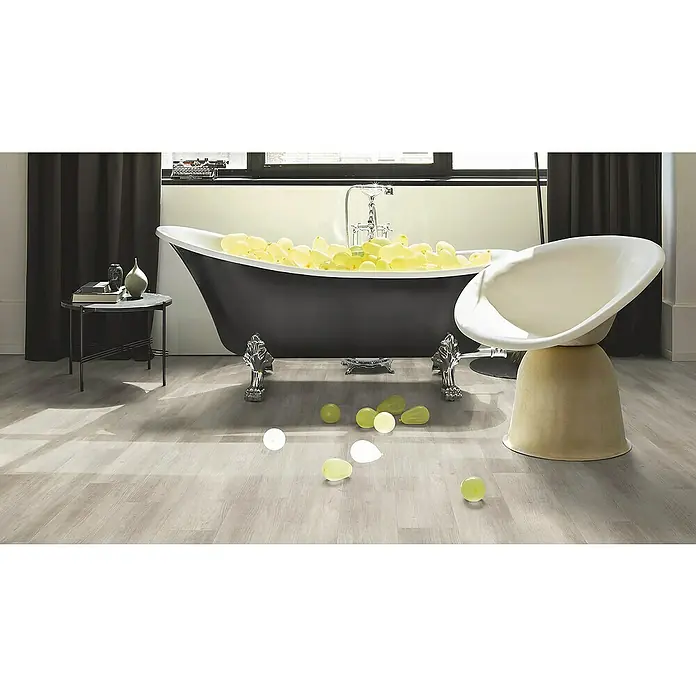 Parador Designbodenmuster Modular ONE Pinie rustikal grau - 200 x 194 x 8 mm, Landhausdiele - Elegantes Badezimmer mit freistehender Badewanne, stilvollem Sessel und verspielten Ballons für eine entspannte Atmosphäre.