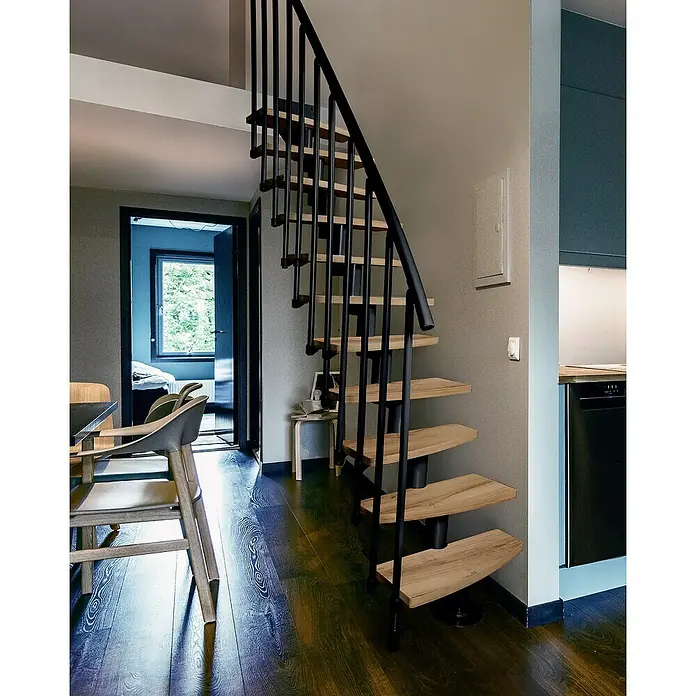 Atrium Raumspartreppe Mini Plus Vertical - Farbton Metall: RAL 9005, Breite: 60 cm, Eiche, Geschosshöhe: 222 cm - 300 cm - Holztreppe mit schwarzem Geländer in modernem Interieur. Die Wendeltreppe fügt sich elegant in das Raumdesign ein und bietet einen stilvollen Zugang.