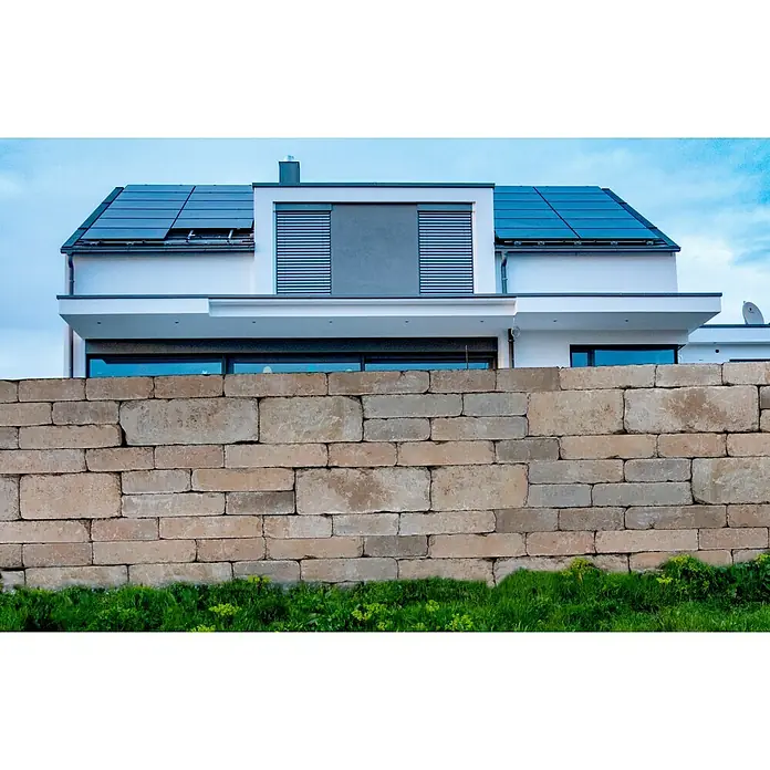 EHL Mauerstein Times Antik L - 20 x 20 x 14 cm, Sandstein, Beton - Moderne Hausansicht mit Solarzellen und Steinmauer im Vordergrund. Nachhaltigkeit trifft auf zeitgenössische Architektur für ein umweltfreundliches Zuhause.