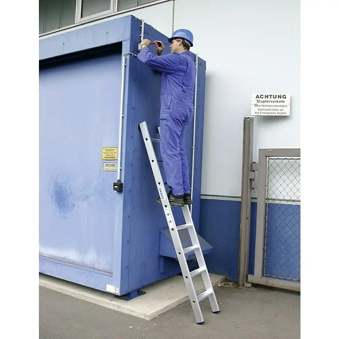 Krause Stabilo Anlegeleiter + S - Anzahl Tritte: 8 Stk., Arbeitshöhe: 3,15 m, Aluminium - Ein Arbeiter auf einer KRAUSE Stehleiter repariert eine blaue Anlage im Freien. Die Leiter ist aus Aluminium und hat rutschfeste Füße.