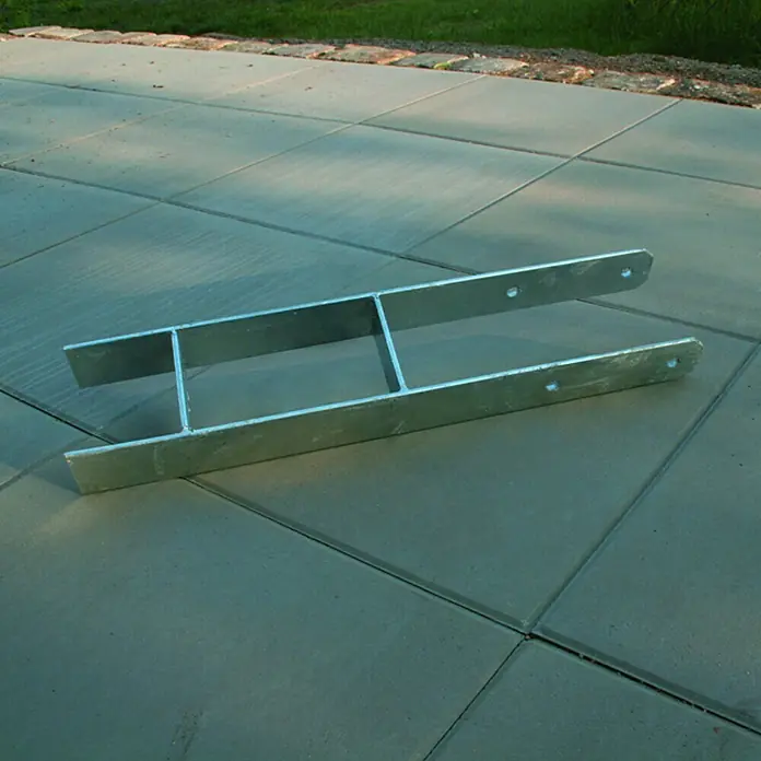 Karibu H-Pfostenanker - Geeignet für: Holzpfosten 12 x 12 cm, 4 Stk. - Nahaufnahme einer silbernen, H-förmigen Metallstütze auf einem Pflaster, die Robustheit und Funktionalität in der Bauweise vereint.