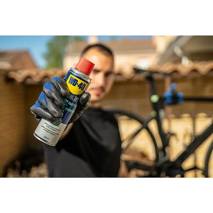WD-40 Bike Aceite para cadenas Total - 250 ml - Hombre sujetando lubricante de cadena WD-40 para bicicletas.