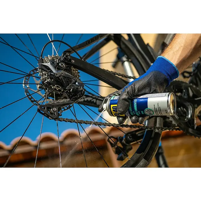 WD-40 Bike Aceite para cadenas Total - 250 ml - Alguien rocía lubricante para cadenas de bicicleta WD-40 en la cadena de una bicicleta para mantenerla y asegurar un pedaleo suave.