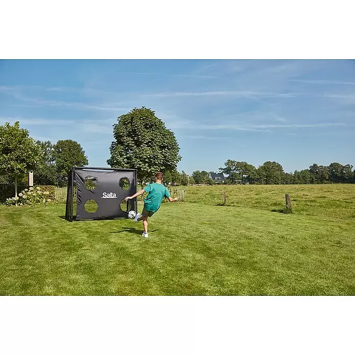 Salta Fußballtor - 220 x 80 x 170 cm, Schwarz - Schwarzes Fußball-Zieltor mit Löchern, ein Junge schießt einen Ball darauf.