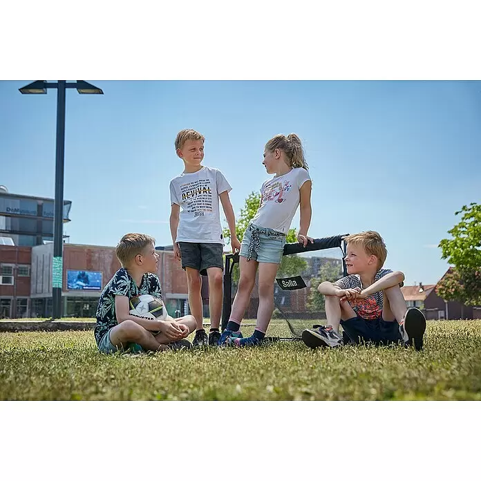 Salta Fußballtor - 100 x 60 x 60 cm, Schwarz, 2 Stk. - Vier Kinder spielen draußen mit einem schwarzen Salta-Faltfußballtor. Zwei stehen, zwei sitzen im Gras.